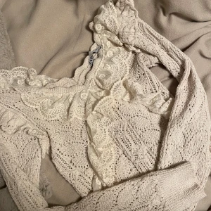 Beige spetsprydd stickad tröja från Zara - Charmig beige stickad tröja från Zara med vackra spetsdetaljer. Jättebra skick