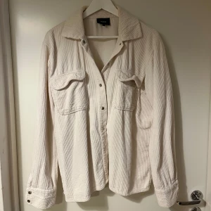 Beige overshirt från Object - Säljer en stilren beige overshirt från Object i manchester. Skjortan har långa ärmar och knappar framtill samt två bröstfickor med lock. Funkar både som overshort samt jacka.