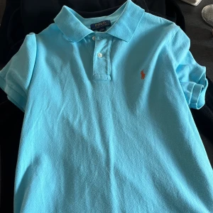 Två Polo Ralph Lauren pikétröjor - Säljer två snygga Polo Ralph Lauren pikétröjor i storlek S. Den ena är ljusblå och den andra är ljusrosa. Båda tröjorna har korta ärmar och en klassisk krage med två knappar. Perfekta för både vardag och fest! 💙💗 du får både för 500kr och enskild 250kr, kontakta mig vid minsta frågan 