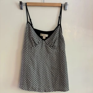 Svartvit mönstrad linnetopp - Säljer mitt slip-on linne från Michael Kors, amerikansk XS så den passar både dig som både kan bära XS/S! Funkar både till vardags och fest, syns dåligt på bilderna men det är ett satinmaterial! Banden går att justera - osynlig dragkedja i sidan - haft i några år men aldrig använt pga sitter inte bra över bysten på mig.