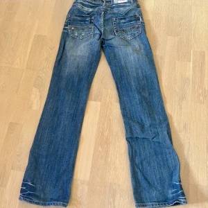 Lågmidjade bootcut jeans  - Lågmidjade bootcut jeans, dragkedjan är sönder men syns ej när man har de på sig. Midjemått 35 cm, innerbenslängd 79 cm. 