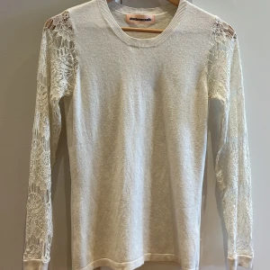 Vit tröja med spetsärmar från Custommade - Säljer en superfin vit tröja från Custommade. Den har långa ärmar med vackra spetsdetaljer som gör den extra speciell. Perfekt för både vardag och fest! Tröjan är i bra skick och väldigt bekväm att ha på sig. Det står ingen storlek i den men skulle säga att den är i storlek s/xs.💖