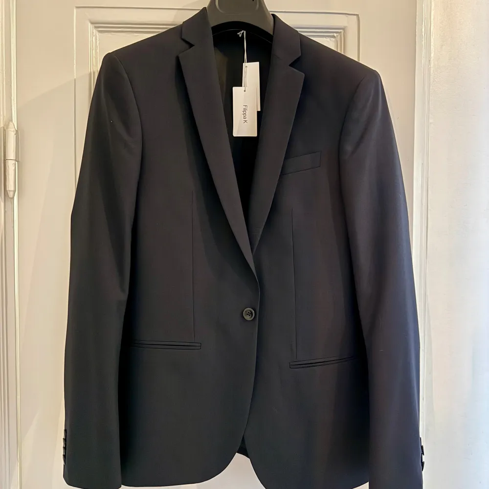 Oanvänd Filippa K M. Christian Cool Wool Jacket Dark Navy (Nypris: 3000 kr)  • Enknäppt kavaj från Filippa K. • Material: 100% ull • Smal passform  Två infällda fickor i sidorna, en bröstficka samt tre innerfickor.  Skickas ej. Hämtas på Kungsholmen.. Kostymer.