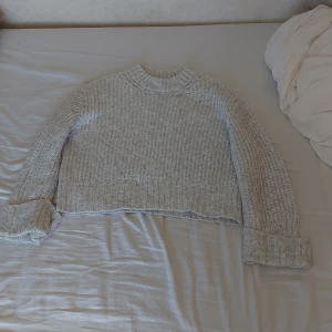 Grå stickad tröja från Gina Tricot - Säljer en superfin grå stickad tröja från Gina Tricot. Den är croppad och har långa ärmar med uppvikta muddar. Perfekt för höst och vinter, har använt den ganska så mycket men set ut o va i nyckick! Passar både till jeans och kjol. Skön och mysig, perfekt för kyliga dagar. 💛