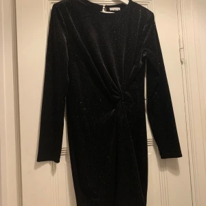 Black dress  - Jättefin svart klänning med glitter. Klänningen har en knut på sidan och insydda puffärmar. Storlek L, från H&M, använd två gånger.