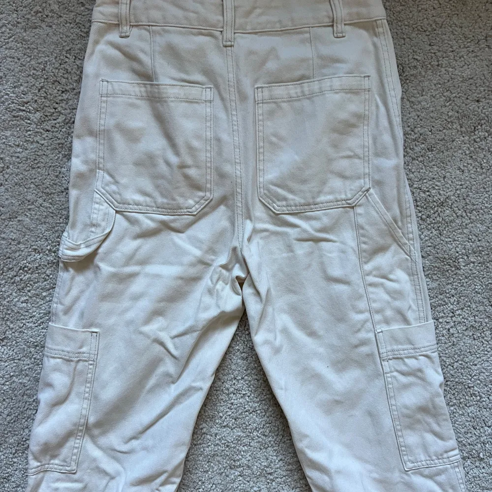 Högmidjade, raka jeans i cargo-stil. Nyskick, offwhite (ljus beige) färg. . Jeans & Byxor.