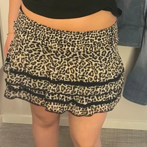 Leopardmönstrad kjol med volanger - Säljer en superfin leopardmönstrad kjol med volanger. Den är kort och har en elastisk midja som gör den bekväm att bära. Perfekt för en fest eller en utekväll! 🐆✨