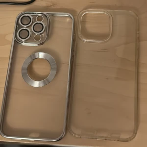 Genomskinliga mobilskal - Säljer två genomskinliga mobilskal. Ett av skalen har en metallring runt kameran och en cirkel på baksidan, perfekt för att fästa på magnetiska hållare. Det andra skalet är helt genomskinligt utan några extra detaljer. Båda skalen är i bra skick och skyddar din mobil effektivt.