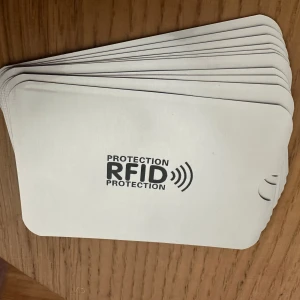 Vita RFID-skyddsfodral - Säljer en bunt vita RFID-skyddsfodral som skyddar dina kort mot obehörig skanning. Perfekt för att hålla dina kreditkort och ID-kort säkra. Fodralen är tunna och lätta att använda i din plånbok eller väska.