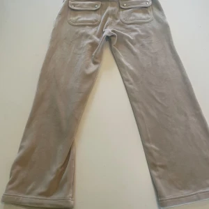 Juicy byxa - Beige Juicy-byxa. Har lite röd färg framtill. 