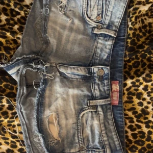 Blå jeansshorts från NOW - Snygga blå jeansshorts med slitna detaljer och fransar. Perfekta för en avslappnad stil. De har en klassisk femficksdesign och knappgylf. Väldigt lågmidjade och korta vid låren och röven👍