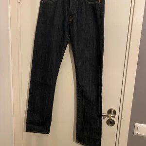 Levi's 501 Jeans - Klassiska Levi's 501 jeans i mörkblå denim. Dessa jeans har en rak passform och är tillverkade av högkvalitativt denimtyg. Perfekta för en tidlös stil. Aldrig använda 