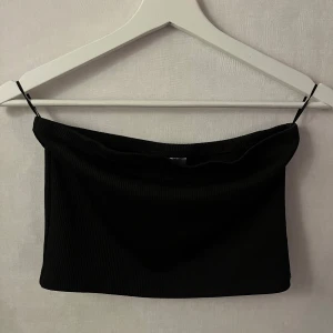 Svart tubtopp från lager 157 - Snygg svart tubtopp från lager 157. Perfekt för en stilren look, enkel att matcha med olika outfits. Tillverkad i ett stretchigt material för en bekväm passform.