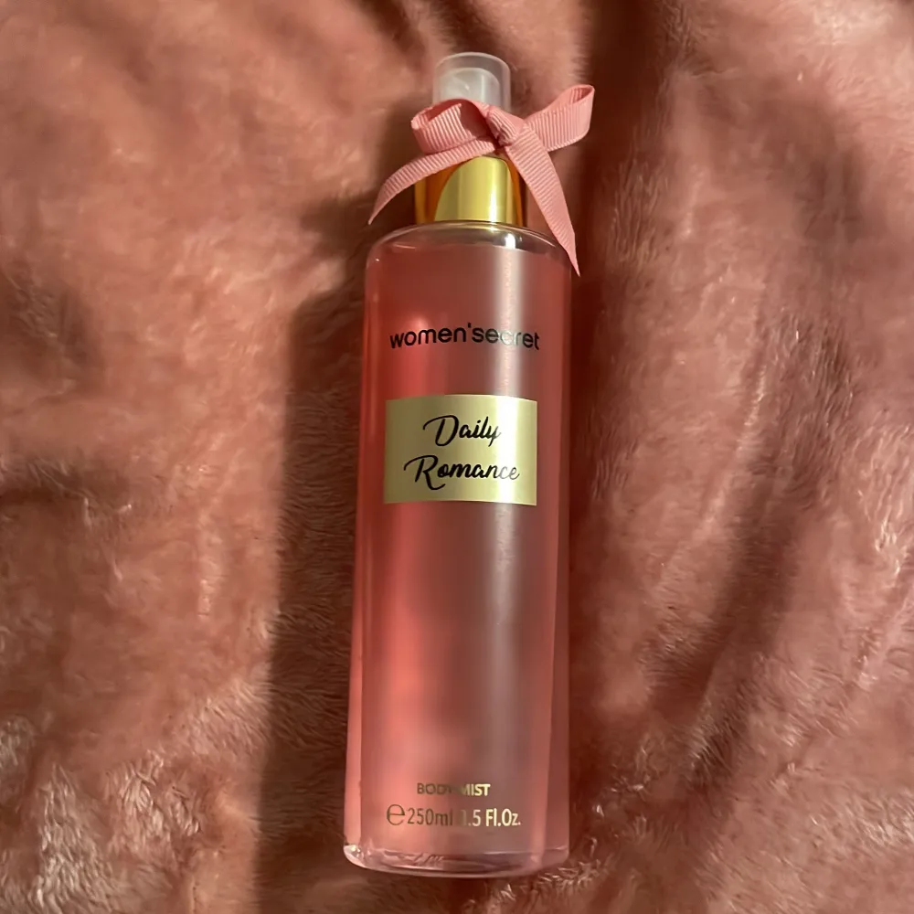 Fräsch och romantisk body mist i en elegant rosa flaska med gulddetaljer och en söt rosett på korken. Perfekt för en daglig doftuppfräschning.. Perfume.
