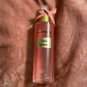 Daily Romance Body Mist från Women'secret - Fräsch och romantisk body mist i en elegant rosa flaska med gulddetaljer och en söt rosett på korken. Perfekt för en daglig doftuppfräschning.