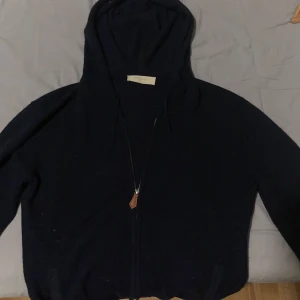 Mörkblå hoodie från Sayless - Säljer en mörkblå hoodie från sayless med dragkedja och huva. Perfekt för kyliga dagar. Den har långa ärmar och en stilren design.