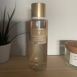 Shimmering Shores Body Mist från Victoria's Secret - Mist från Victoria's Secret i doften ”Shimmering Shores”.  Sååå god somrig kokosnöt med lite vanilj doft, men använder inte längre. Använd, men mycket kvar (ca 3/4 eller 2/3 kvar)