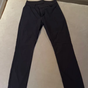 Svarta byxor från Peak Performance - Snygga svarta byxor från Peak Performance med en stilren design. Perfekta för en casual look eller mer uppklädda tillfällen. Byxorna har en smal passform och är tillverkade i ett bekvämt material.