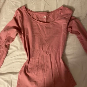 Rosa långärmad topp från lager 157 - Säljer en söt rosa långärmad topp från 157 i storlek XS. Tillverkad i mjuk bomull med lite elastan för extra komfort. Perfekt för en avslappnad stil.