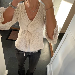 Vit omlottkofta med volanger  - Vit stickad/spets kofta från Lilly of Sweden i storlek S. Fint skick. Använd gärna köp nu!