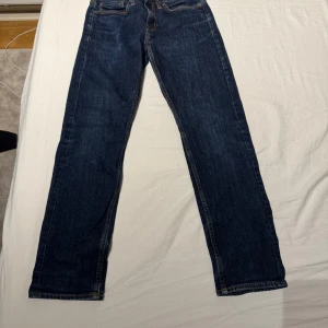 Mörkblå jeansbyxor - Snygga mörkblå jeansbyxor med klassisk design. De har en rak passform och är perfekta för en avslappnad stil. Byxorna har knappar och dragkedja framtill. W:29 längd 32. Pris kan diskuteras