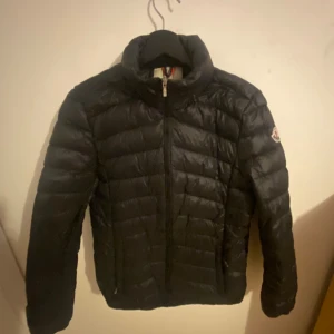 Moncler dunjacka  - Säljer en stilren svart dunjacka från Moncler. Jackan har en quiltad design med dragkedja framtill och långa ärmar. Perfekt för kyligare dagar och ger en snygg look. Moncler-loggan syns på ärmen. Priset är ej hug i sten 