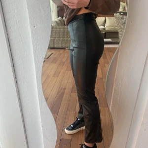 Svarta skinnbyxor - Snygga svarta skinnbyxor med hög midja och tight passform. Perfekta för en stilren Look. 