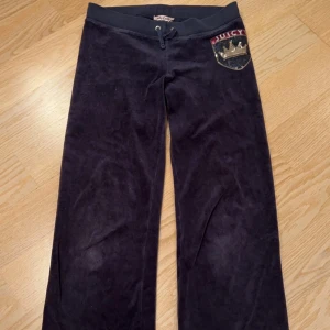 Mörkblå mjukisbyxor från Juicy Couture - Snygga mörkblåa vintage mjukis byxor från Juicy Couture i mjukt material med paljettbroderi. Dem är en gammal modell från runt 2005-2013 tror jag. Dem är i storlek XL i barnmodell så runt storlek 146-152. Säljer pga att dem är för korta på mig. Skriv för mer frågor eller bilder. Lägg prisförslag, godkänner vissa!💕