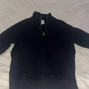 Svart tröja med dragkedja från Zara - Säljer en svart tröja från Zara med dragkedja vid halsen. Perfekt för en avslappnad stil. Tröjan har en enkel design och är tillverkad i ett mjukt material.