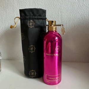 Roses Musk Eau de Parfum från Montale - Säljer en lyxig parfym från Montale i doften Roses Musk. Parfymen har endast använts två gånger innan jag insett att jag är allergisk. Flaskan är i en glänsande rosa metall med guldfärgad spraypump och detaljer. Parfymen kommer med en elegant svart påse med gulddetaljer för förvaring. Den har minst 98 ml kvar vilket räcker i 1-2 år beroende på grad av användning💛