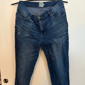 Blå jeansbyxor - Snygga blå jeansbyxor med klassisk femficksdesign och dragkedja. Perfekta för en avslappnad stil. Passar bra till både sneakers och kängor. Storlek 35