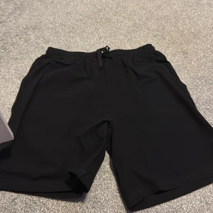 Linneshorts - Snygga svarta shorts med dragsko i midjan för en bekväm passform. Perfekta för en avslappnad stil eller träning. Tillverkade i ett mjukt och flexibelt material som ger rörelsefrihet.