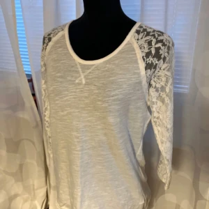 Linne med spets från HM - I mycket bra skick, använd någon gång, köpt på HM, strl XS, lite stretch, trekvartslånga ärmar av spets, bomul för det mesta. I mjölkvit färg.