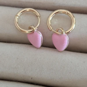 Guldörhängen med rosa hjärtan - Charmiga guldörhängen med hängande rosa hjärtan.  Aldrig har använts. jag har tyvärr ingen information om vare sig märke eller material.postar inom tre dagar efter köpet 