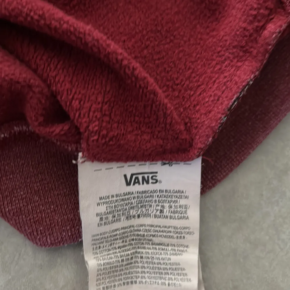 Säljer en snygg vinröd hoodie från Vans med stor logga på bröstet. Tröjan har en klassisk känguruficka och en bekväm huva. Perfekt för en avslappnad stil.. Hupparit & Collegepaidat.