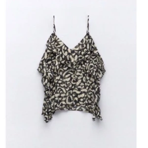 Svart och vit leopardmönstrad topp från Zara - Snygg svart och vit leopardmönstrad topp från Zara med tunna axelband och volangdetaljer som är slutsåld. Toppen är i storlek S och har aldrig använts❣️ 