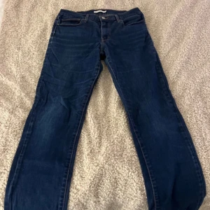 Mörkblå jeans från Levi's - Snygga mörkblå jeans från Levi's med klassisk design. Perfekta för en avslappnad stil. Levi's ikoniska röda etikett syns på bakfickan.