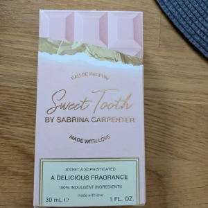 Sweet Tooth Eau de Parfum av Sabrina Carpenter - Sweet Tooth är en Eau de Parfum med en söt och sofistikerad doft. Flaskan är formad som en rosa chokladkaka, vilket ger en lekfull och unik design. Parfymen innehåller 30 ml och är tillverkad med kärlek och indulgenta ingredienser. Sprayat nåfra få sprut