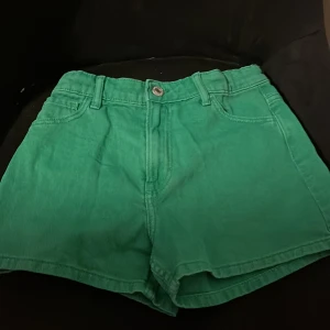 Gröna shorts från H&M - Snygga gröna shorts från H&M i en härlig färg. De har en klassisk design med knapp och dragkedja framtill samt fickor både fram och bak. Perfekta för en avslappnad stil.