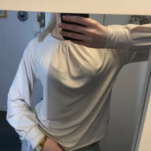 Beige blus - Svin snygg blus med rund halsringning och diskreta veckdetaljer framtill. Toppen har en knappdetalj i nacken och är perfekt för en elegant look!😍