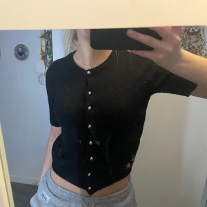 Svart stickad kortärmad tröja - Svart elegant stickad tröja med korta ärmar och knappar framtill🤩🖤