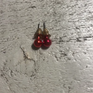 Röda pärlörhängen - Snygga röda pärlörhängen med en glansig finish. Perfekta för att lägga till en färgklick till din outfit. De har en enkel och elegant design som passar till många tillfällen.
