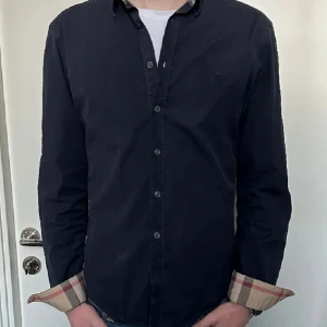 Burberry skjorta  - Säljer nu en snygg mörkblå burberry skjorta! Fint skick men absolut inte ny… Tveka inte att höra av er vid frågor.