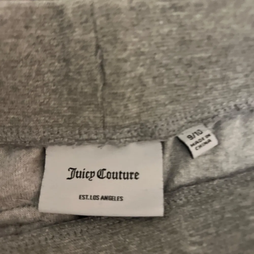 Superbekväma grå mjukisbyxor från Juicy Couture med breda ben. Byxorna har snörning i midjan, lågt pris pga att ena metall saken på snöret lossnat. Perfekta för en avslappnad dag hemma eller en chill dag ute. Fint skick annars men dom är något urtvättade. bra skick förutom snöret som jag beskrev. Stl 9-10 år. Kostar 200kr + frakt. Nypris 850. Priset är diskuterbart. Jeans & Byxor.