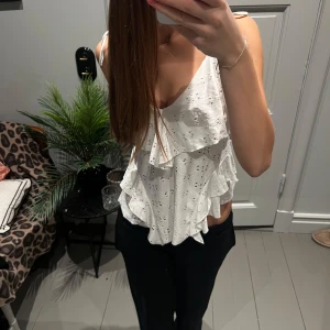 Vit linne - Säljer en superfin vit litefrån Zara i storlek s. Toppen har ett vackert broderat mönster och volangdetaljer. Perfekt för sommardagar. Den är i mycket bra skick och är aldrig använt. 