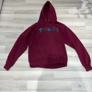 Vinröd hoodie från Thrasher - Säljer en cool vinröd hoodie från Thrasher. Den har en klassisk passform med en stor ficka fram och en justerbar huva. Perfekt för skate eller chill dagar. Märket är tryckt i en färgglad design på bröstet. Grymt skön och stilren! Storlek S eller XS.  90% bomull 10% polyester
