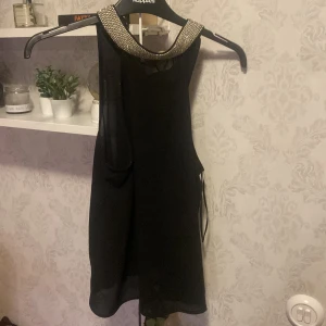 Svart topp  Bik Bok - Snygg svart topp från Bik Bok i storlek S. Några av ”stenarna” har ramlat av, annars är den i fint skick. 