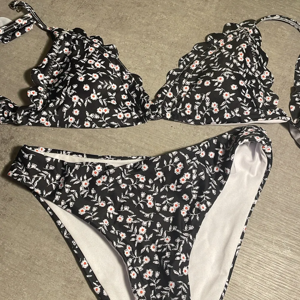 Säljer en superfin svart bikini med sött blommönster och volangdetaljer. Helt oanvänd, från SHEIN💕. Övrigt.