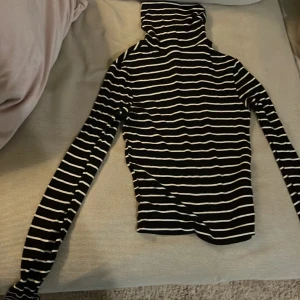 Svartvit randig polotröja från H&M Divided - Säljer en snygg svartvit randig polotröja från H&M Divided. Perfekt för höst och vinter med sin mysiga polokrage och långa ärmar. Tröjan är i bra skick och passar både till vardags och lite finare tillfällen. Ett måste i garderoben för den stilmedvetna!