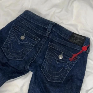 True religion jeans  - Säljer ett par snygga mörkblå true religion jeans, med coola glitter/sten detaljer på låret o snygga bakfickor. De har en låg midja och är boot cut. Perfekta för vardag eller när du vill ha en edgy look. De är i ny skick, pris kan diskuteras. (Skriv om du har frågor)❤️